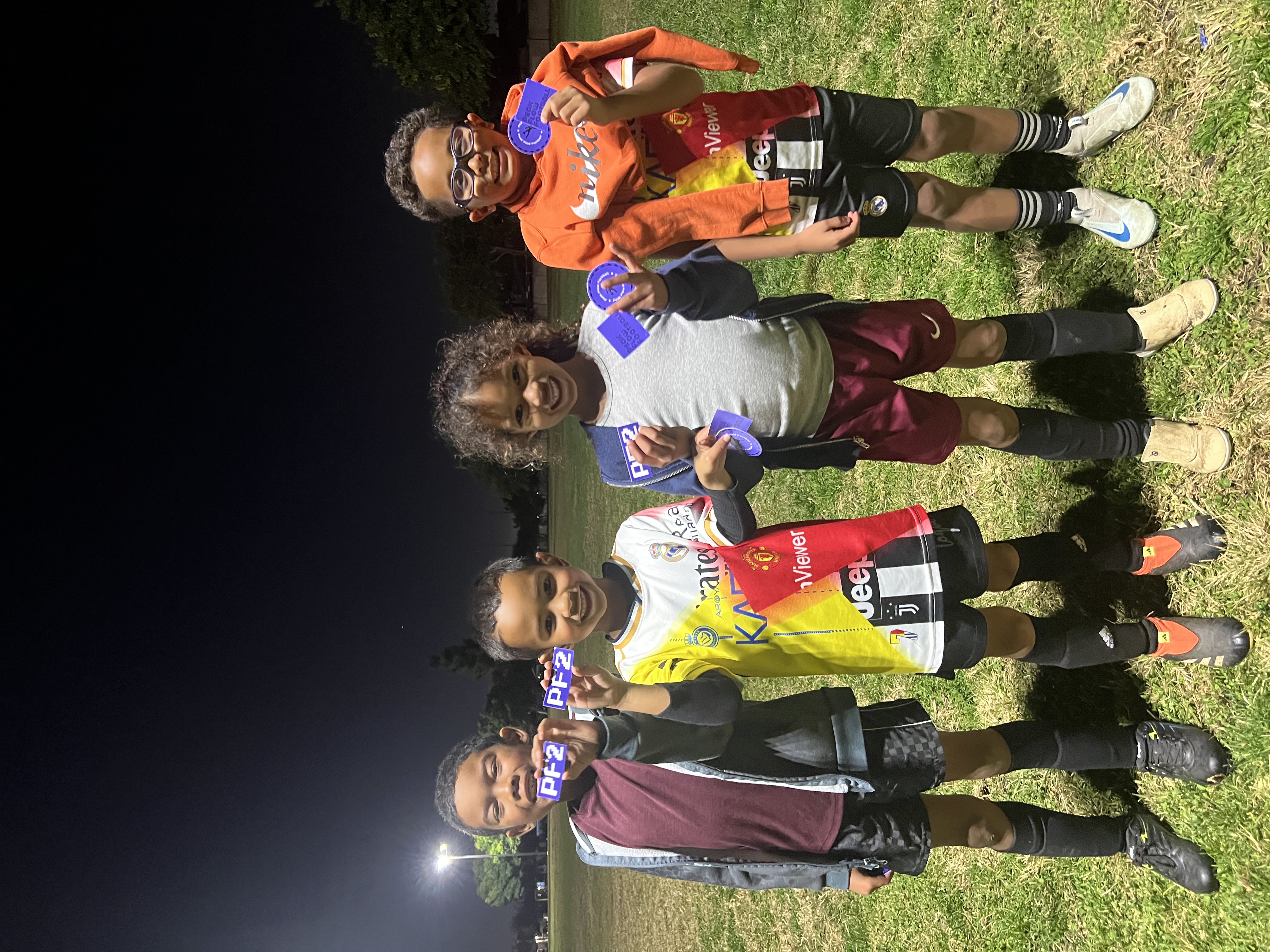 Young players showing off Peak Flow Football stickers after a night session